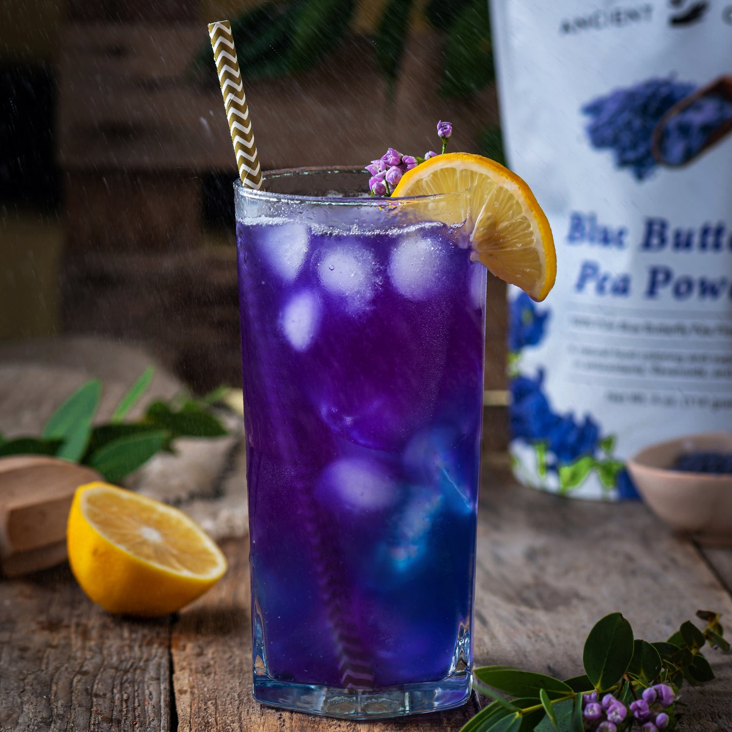 Iced butterfly pea lemonade made with Ancient Choice Butterfly Pea Flower Powder, garnished with a lemon slice and showing a natural color change from blue to purple.