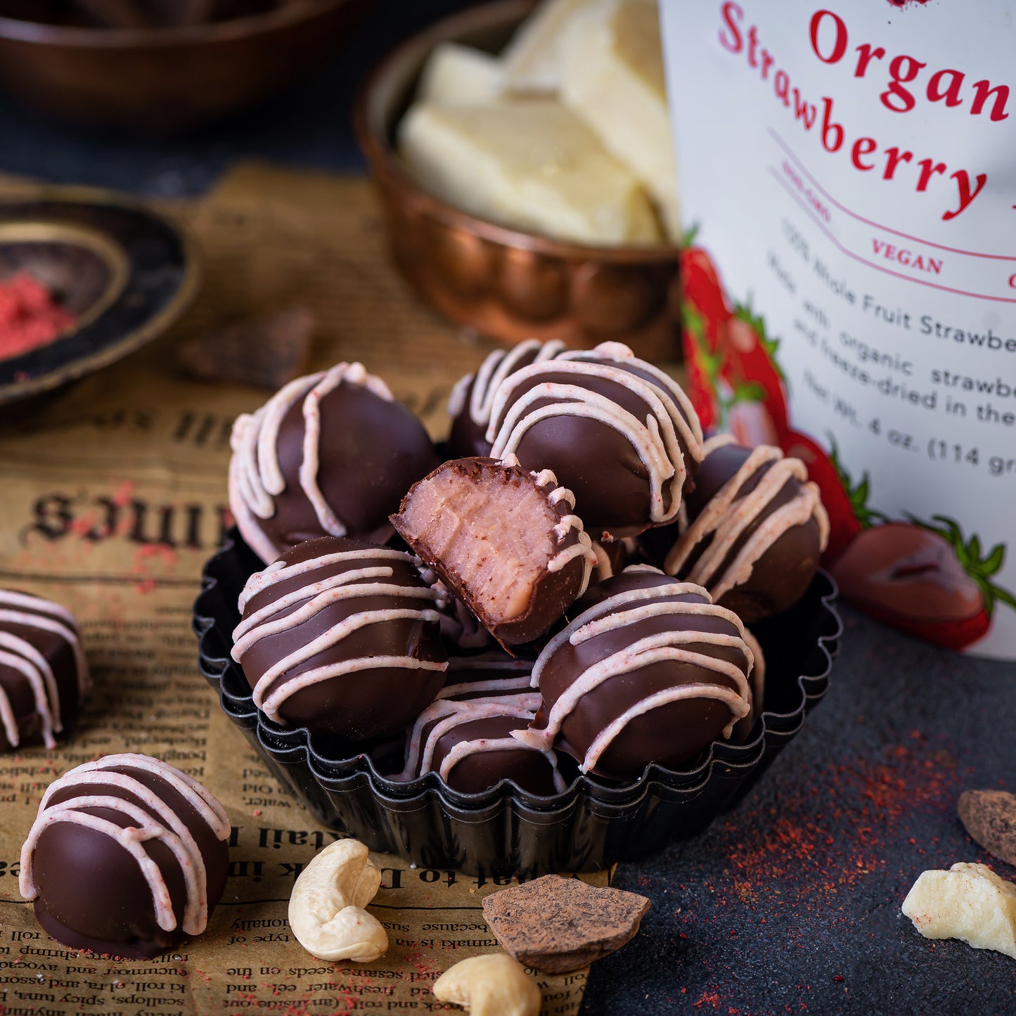 Truffles made with Ancient Choice Strawberry Powder, coated in dark chocolate and drizzled with pink strawberry glaze.