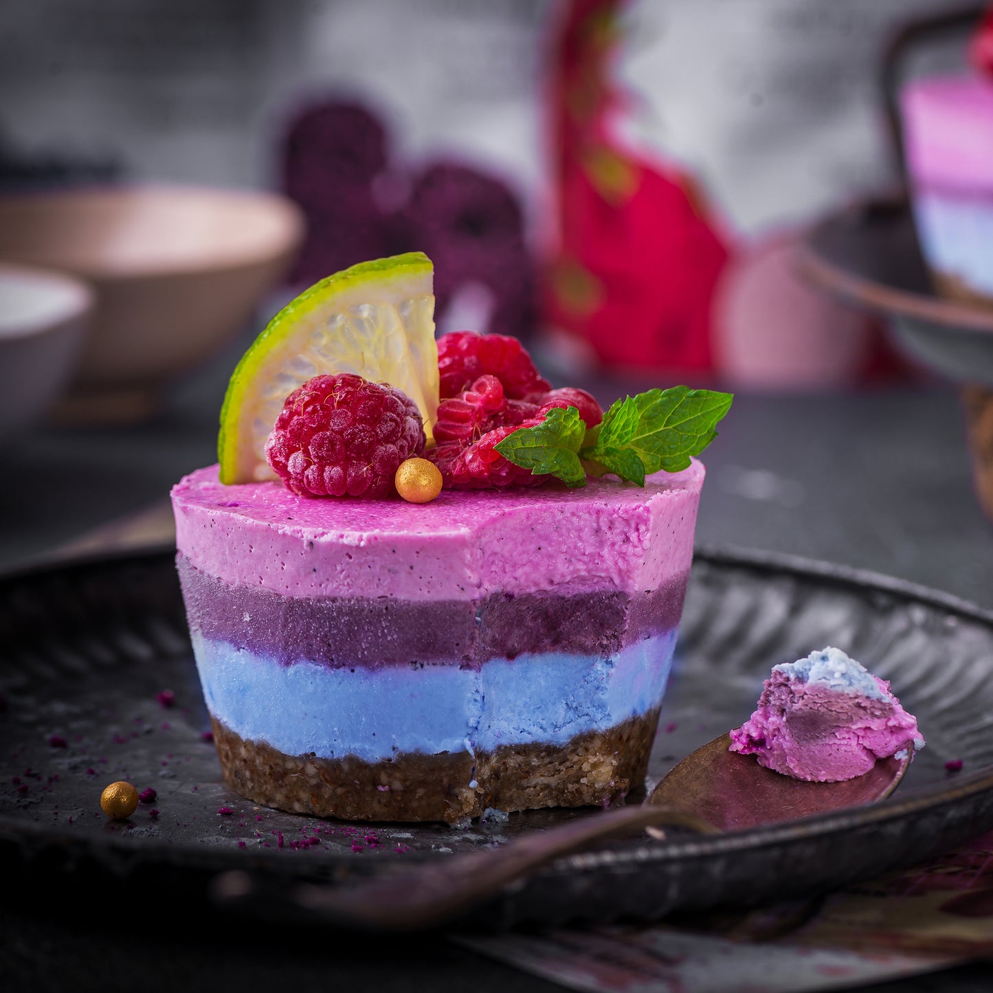 Layered cheesecake made with Ancient Choice Butterfly Pea Flower Powder, Wild Blueberry Powder and Dragon Fruit Powder.