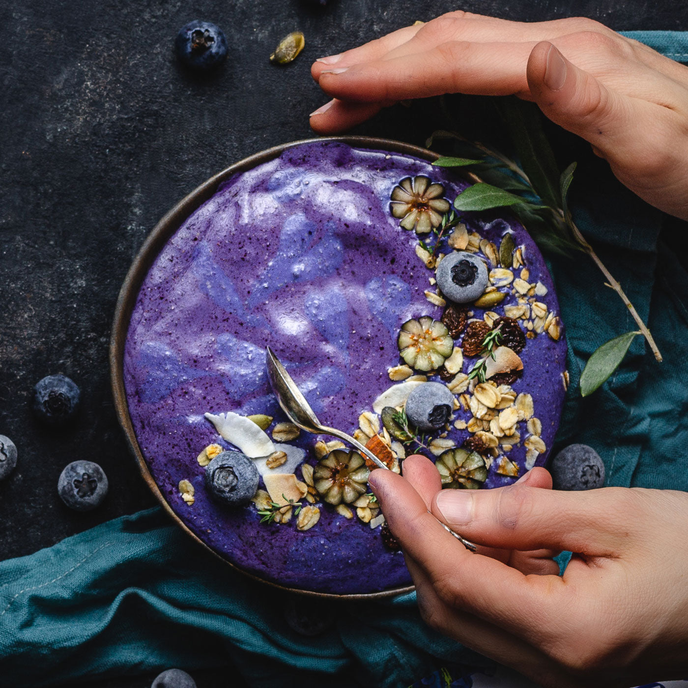 Smoothie bowl made with Ancient Choice Wild Blueberry Powder, topped with granola and frozen blueberries.