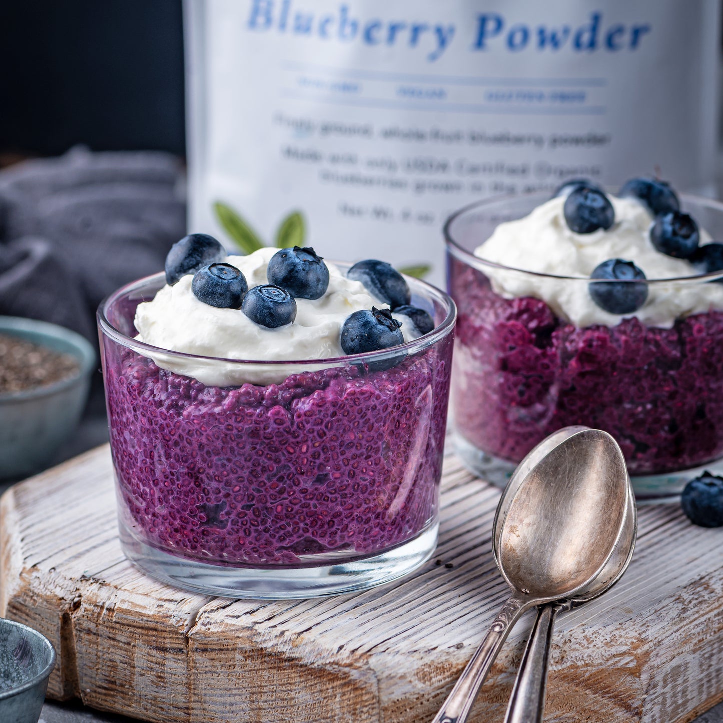 Blueberry chia pudding made with Ancient Choice Wild Blueberry Powder, topped with whipped cream and fresh berries.