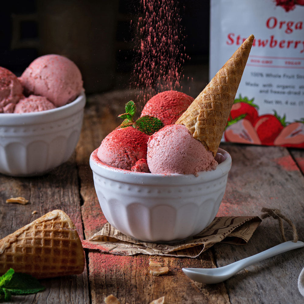 Ice cream made with Ancient Choice Organic Strawberry Powder, topped with a waffle cone, mint garnish, and powder dusting on top.