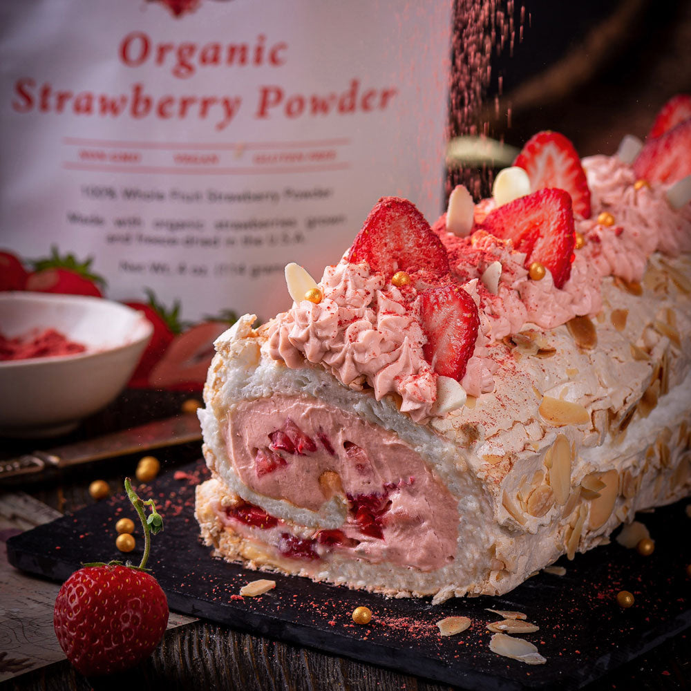 Cream roll cake made with Ancient Choice Strawberry Powder, topped with cream, sliced almonds, and fresh strawberries.