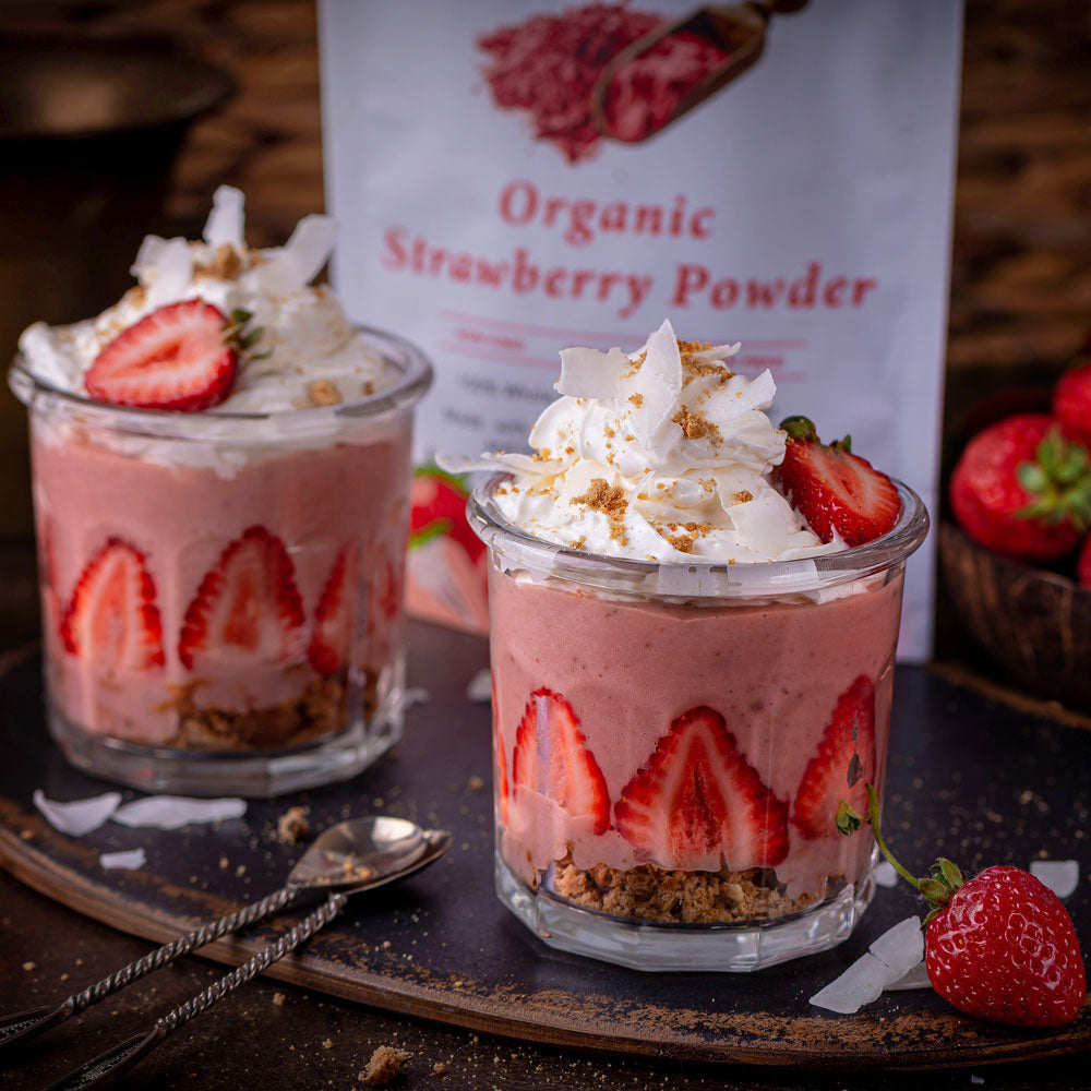 Strawberry parfaits made with Ancient Choice Strawberry Powder, topped with whipped cream, fresh strawberries, and coconut.