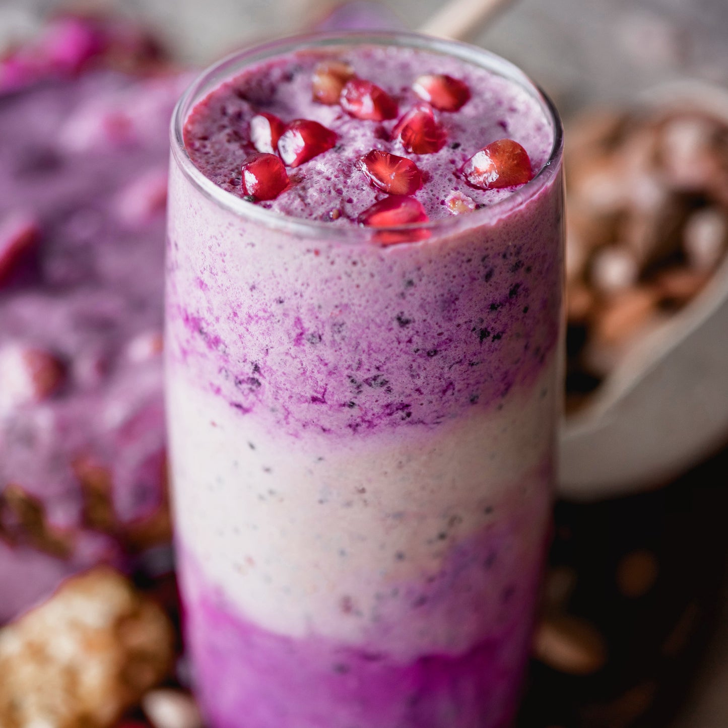 Layered smoothie made with Ancient Choice Dragon Fruit Powder, topped with fresh pomegranate seeds.